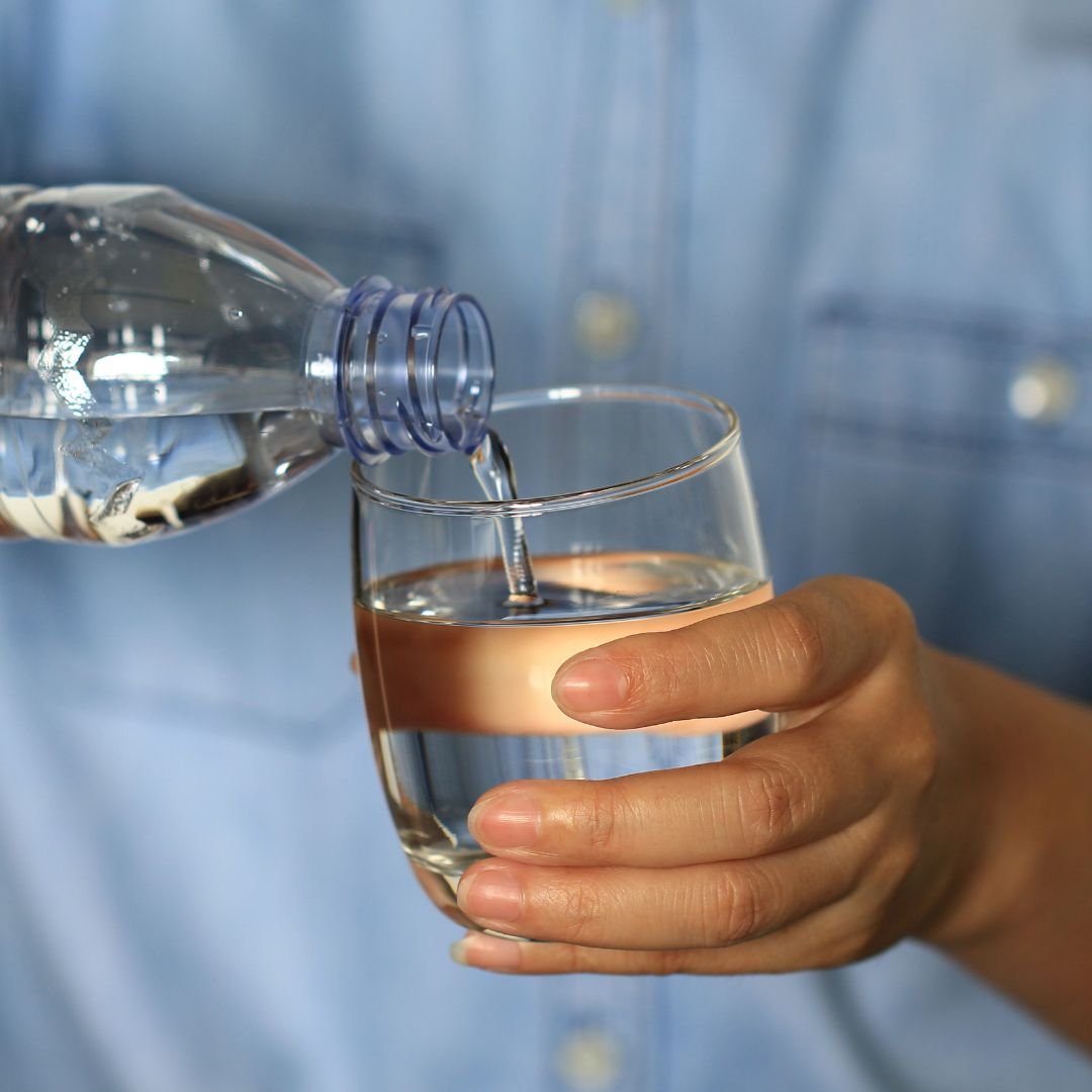 person pouring water into a cup