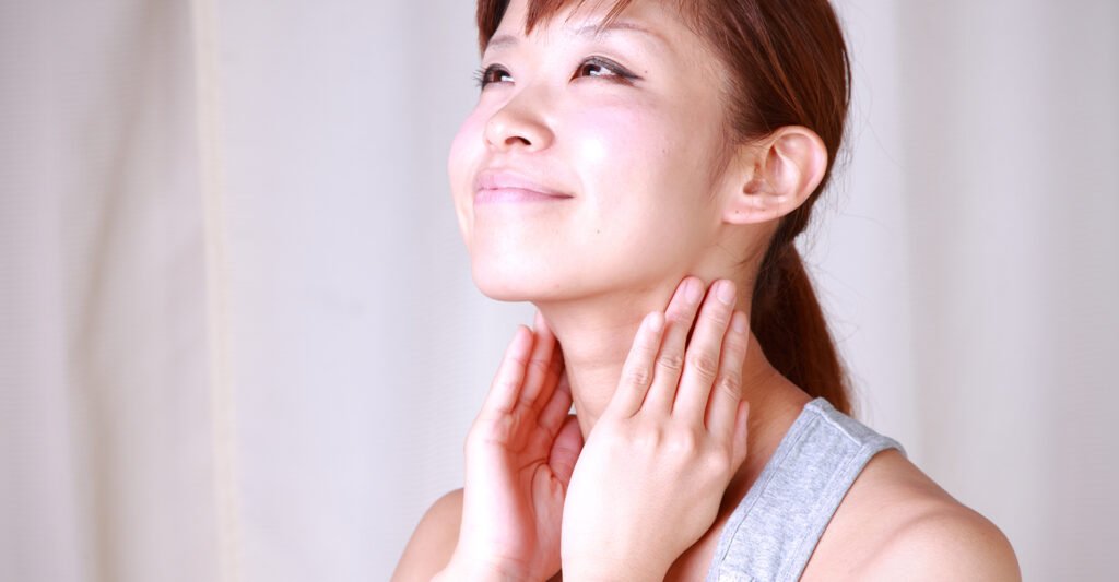 Image of a woman feeling her neck.
